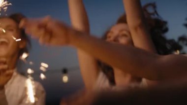 Group friends dancing together at the rooftop with sparkles. Shot with RED helium camera in 8K.  