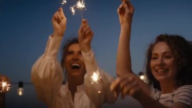 Friends dancing together at the rooftop with sparkles. Shot with RED helium camera in 8K.  