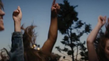 Young friends dancing at the party in top of the roof at evening. Shot with RED helium camera in 8K.  