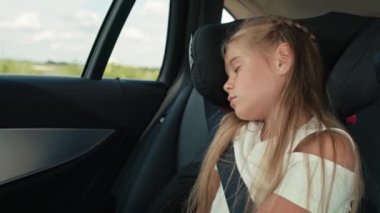 Caucasian little girl sleeping while riding in car. Shot with RED helium camera in 8K.