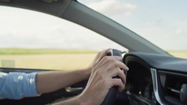 Close up of caucasian man holding hands on steering wheel and moving them. Shot with RED helium camera in 8K.