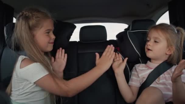 Two Caucasian Female Children Sitting Back Seat Playing Clapping Game — Stockvideo
