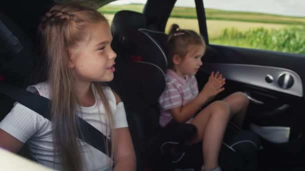 Two Caucasian Female Children Riding Car Back Seat Singing Shot — Stockvideo