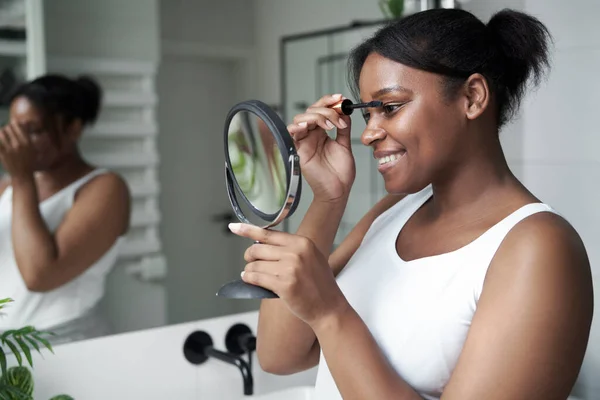 Smiling African American Woman Applying Eyelash Looking Hand Mirror — Stock Photo, Image
