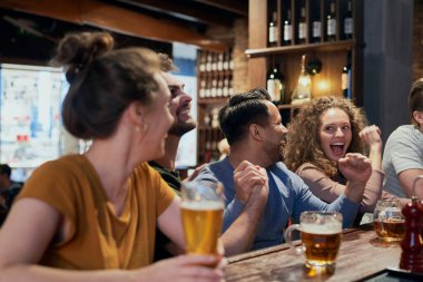 Group of friends spending time in bar together 