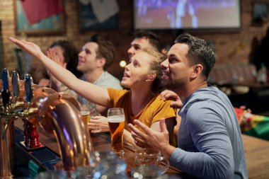 Multiracial group of friends cheering of soccer fans in the pub 