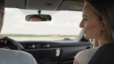 Back view of cheerful caucasian of middle age couple during a car trip. Shot with RED helium camera in 8K.