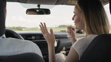 Back view of cheerful caucasian of middle age couple singing during a car trip. Shot with RED helium camera in 8K.