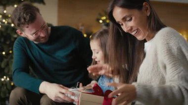 Caucasian family opening Christmas presents at home. Shot with RED helium camera in 8K. 