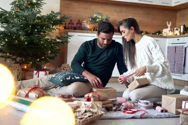 Multi Ethnicity Couple Packing Christmas Present Together Home — Fotografia de Stock