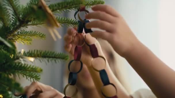 Close Menina Branca Mãe Decorando Árvore Natal Com Cadeia Papel — Vídeo de Stock