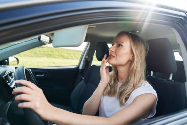 Beyaz kadın arabada makyaj hazırlıyor.