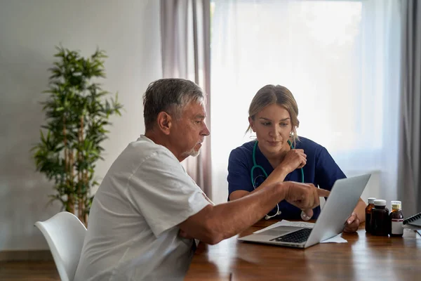 Kaukasische Ärztin Analysiert Medizinische Tests Mit Seniorin Beim Hausbesuch — Stockfoto