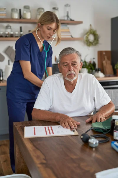 Vit Kvinnlig Läkare Testar Äldre Man Vid Hembesöket Dokument Förbereda — Stockfoto