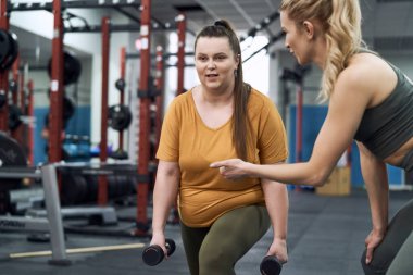 Beyaz kadın spor salonunda kanepede egzersiz yapıyor.