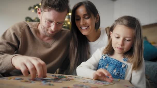 Счастливая Семья Собирает Пазлы Вместе Рождество Дома Съемка Красной Гелиевой — стоковое видео