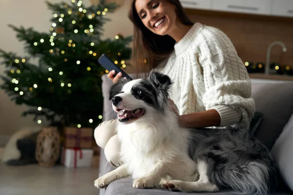 Mulher Com Cachorro Refrigerando Sofá Com Telefone Celular Durante Natal — Fotografia de Stock