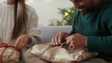 Çok ırklı bir çift benzer Noel hediyelerini evde açıyor. 8K 'da kırmızı helyum kamerayla çekildi..     