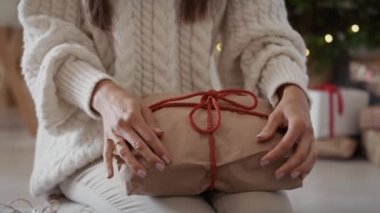 Tanınmayan kadının düşük kesimi Noel hediyelerini paketliyor. 8K 'da kırmızı helyum kamerayla çekildi..
