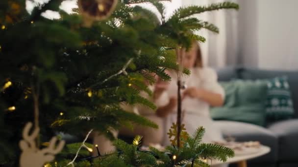 クリスマスツリーにジンジャーブレッドペンダントを作る白人女性と娘 8Kでレッドヘリウムカメラで撮影 — ストック動画