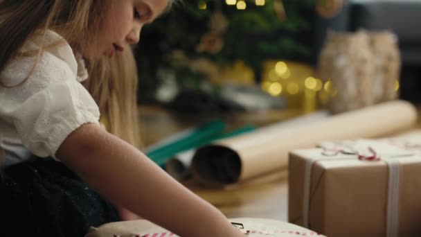 Valkoihoinen Pikkutyttö Käärimässä Joululahjoja Lattialle Laukaus Punaisella Heliumkameralla — kuvapankkivideo