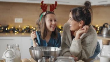 Kafkas kadın portresi ve kızı Noel zamanı mutfakta yemek pişiriyor ve tadımlık alıyor. 8K 'da kırmızı helyum kamerayla çekildi..  
