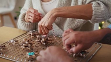 Çoklu etnik kökenli çiftin zencefilli kurabiyeleri küçük bir Noel hediyesi olarak paketlediği videoyu kaldır. 8K 'da kırmızı helyum kamerayla çekildi..  
