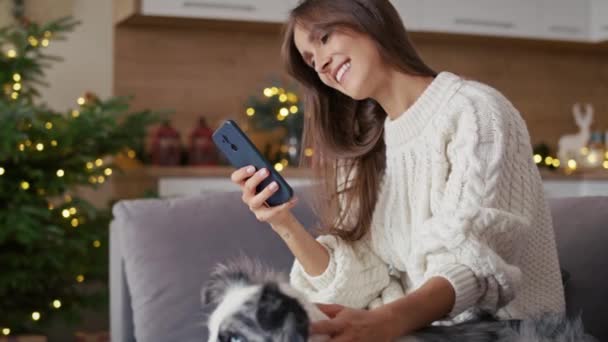 Женщина Отдыхает Собакой Диване Мобильным Телефоном Время Рождества Съемка Красной — стоковое видео