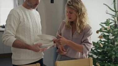 Büyük beyaz bir aile Noel arifesi için masa hazırlıyor. 8K 'da kırmızı helyum kamerayla çekildi..   