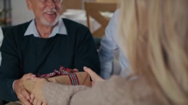 Yaşlı babaya Noel hediyesi veren bir kadın. 8K 'da kırmızı helyum kamerayla çekildi..   