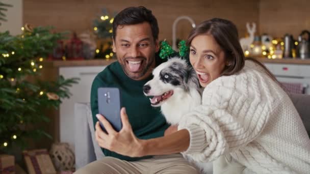 クリスマスの間に家で犬と一緒に写真を撮る幸せな多民族のカップル 8Kでレッドヘリウムカメラで撮影 — ストック動画