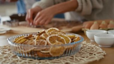 Ön planda kurutulmuş limonlar ve tanınmayan insanların zencefilli kurabiye pişirmesi. 8K 'da kırmızı helyum kamerayla çekildi..      