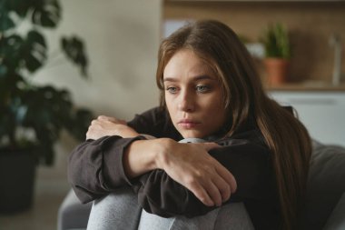 Kafkasyalı üzgün kadın depresyonda kanepede oturuyor.