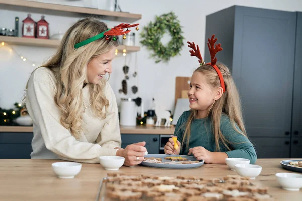 白种人的母亲和女儿在圣诞节装饰姜饼饼干 玩得很开心 — 图库照片