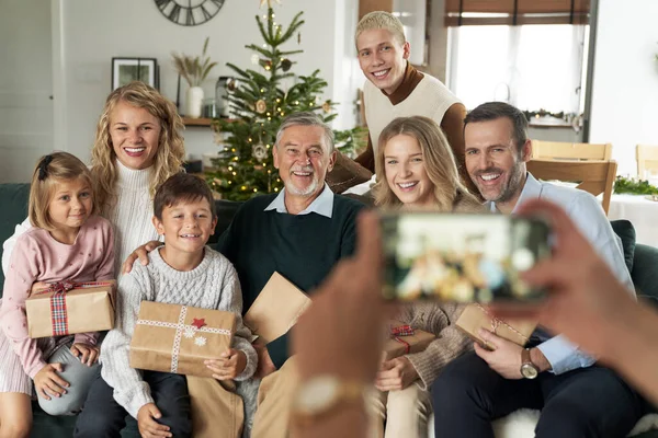 ソファに座ってクリスマスプレゼントを持っている家族の写真を撮る認識できない原因アジア人 — ストック写真