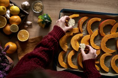 Yukarıdan gelen kadın masada sarımsaklı balkabağı hazırlıyor.