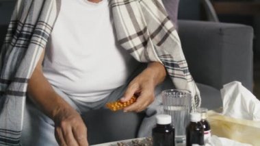 Kıdemli beyaz adam grip sırasında hapları seçiyor. 8K 'da kırmızı helyum kamerayla çekildi..  