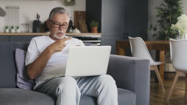 Starszy Biały Mężczyzna Siedzi Kanapie Rozmawia Przez Telefon Nakręcony Aparatem — Wideo stockowe