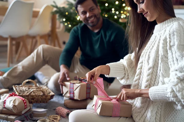 一对快乐的夫妇在家里一起包装圣诞礼物 — 图库照片