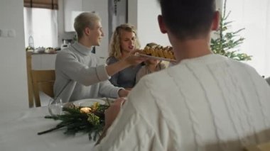 Beyaz bir aile masanın etrafında oturuyor ve Noel 'i birlikte geçiriyorlar. 8K 'da kırmızı helyum kamerayla çekildi.. 