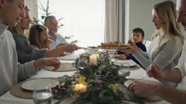 Beyaz bir aile masanın etrafında oturuyor ve Noel 'i birlikte geçiriyorlar. 8K 'da kırmızı helyum kamerayla çekildi.. 
