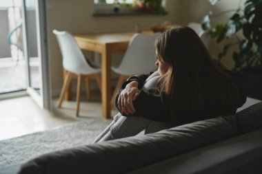 Kafkasyalı üzgün kadın depresyonda kanepede oturuyor.