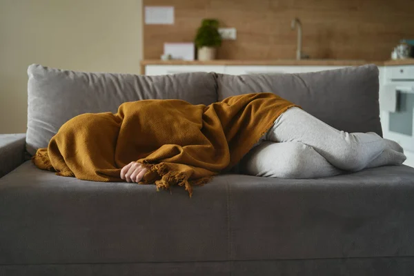 ソファの上に毛布の下に横たわるうつ病を持つ白人女性 — ストック写真