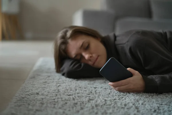 Blanke Nerveuze Vrouw Liggend Vloer Met Mobiele Telefoon — Stockfoto