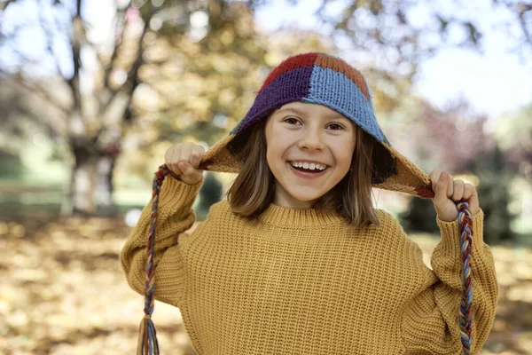 站在树林里戴着一顶有趣的彩色帽子的白人女孩 — 图库照片