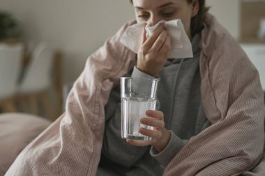 Suda çözünen haplı cam tutan kadına yaklaş.