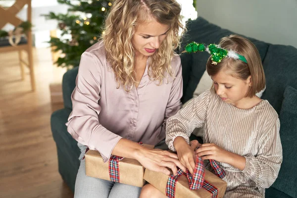 소파에서 크리스마스 포장하고 소녀와 어머니 — 스톡 사진