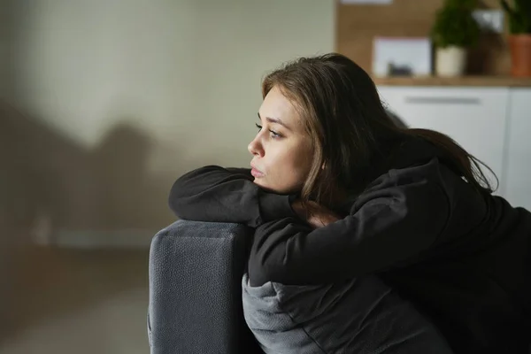 Caucasian terrified woman lying on the sofa and looking away