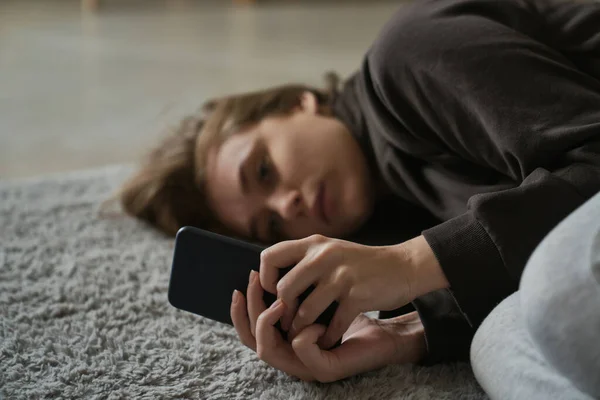 Blanke Nerveuze Vrouw Liggend Vloer Met Mobiele Telefoon — Stockfoto