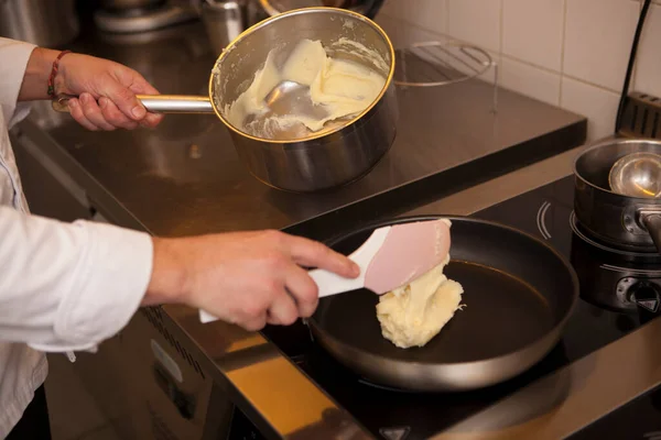 Cropped shot of a chef frying mashed potatoes on a pan